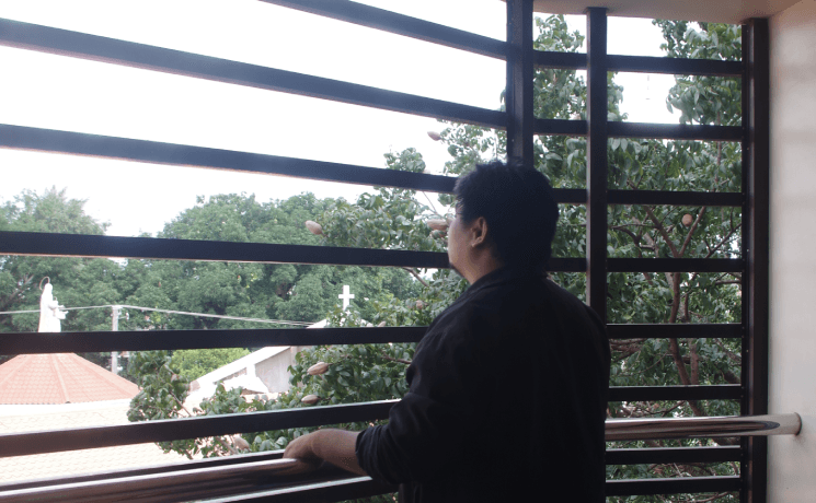 John Rey Silverio looking across a tree-lined campus